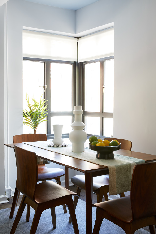 Стильный дизайн: столовая в современном стиле с белыми стенами, темным паркетным полом и коричневым полом - последний тренд