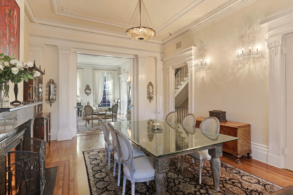 Mid-sized elegant medium tone wood floor enclosed dining room photo in New York with beige walls