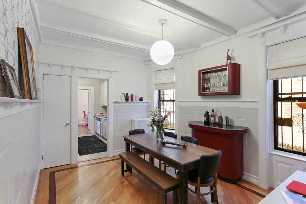 Klassische Wohnküche mit weißer Wandfarbe, braunem Holzboden und braunem Boden in New York