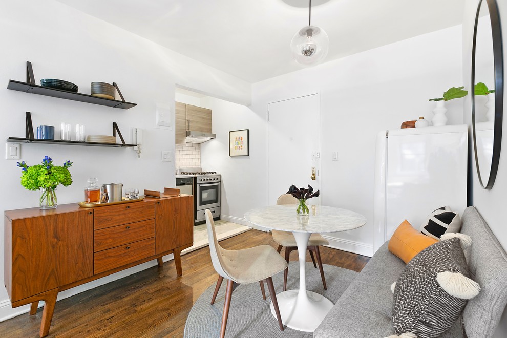 Example of a small danish medium tone wood floor and brown floor great room design in Austin with white walls