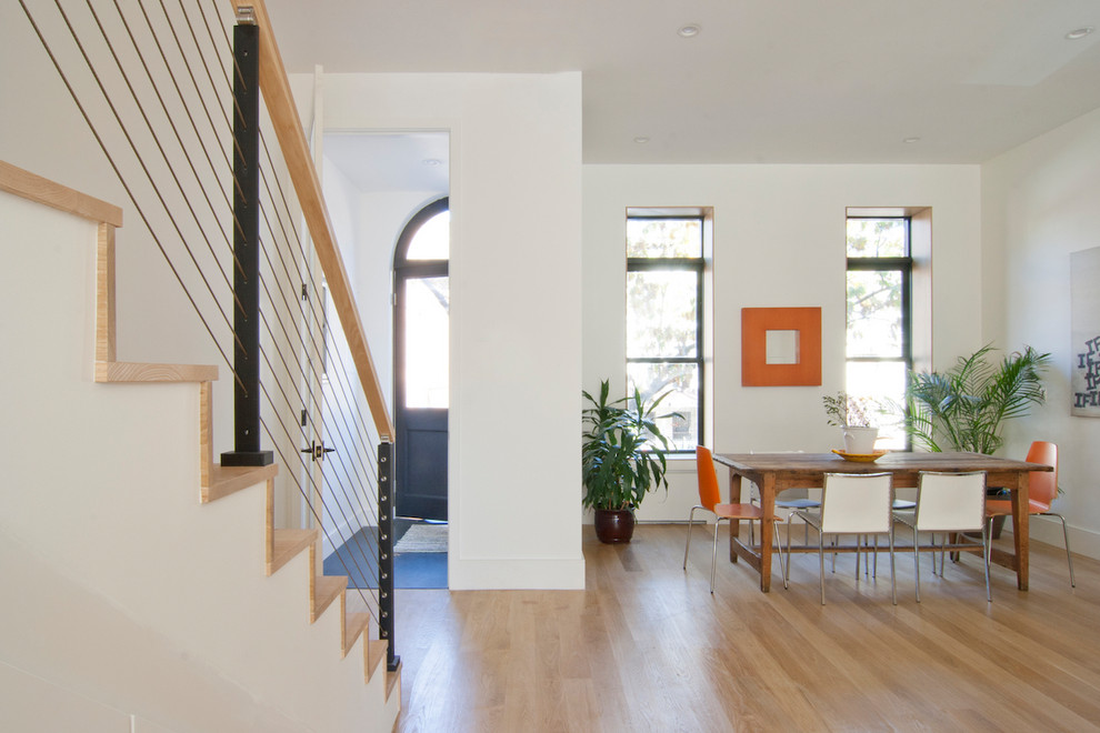 Стильный дизайн: гостиная-столовая среднего размера в современном стиле с белыми стенами, светлым паркетным полом и коричневым полом - последний тренд