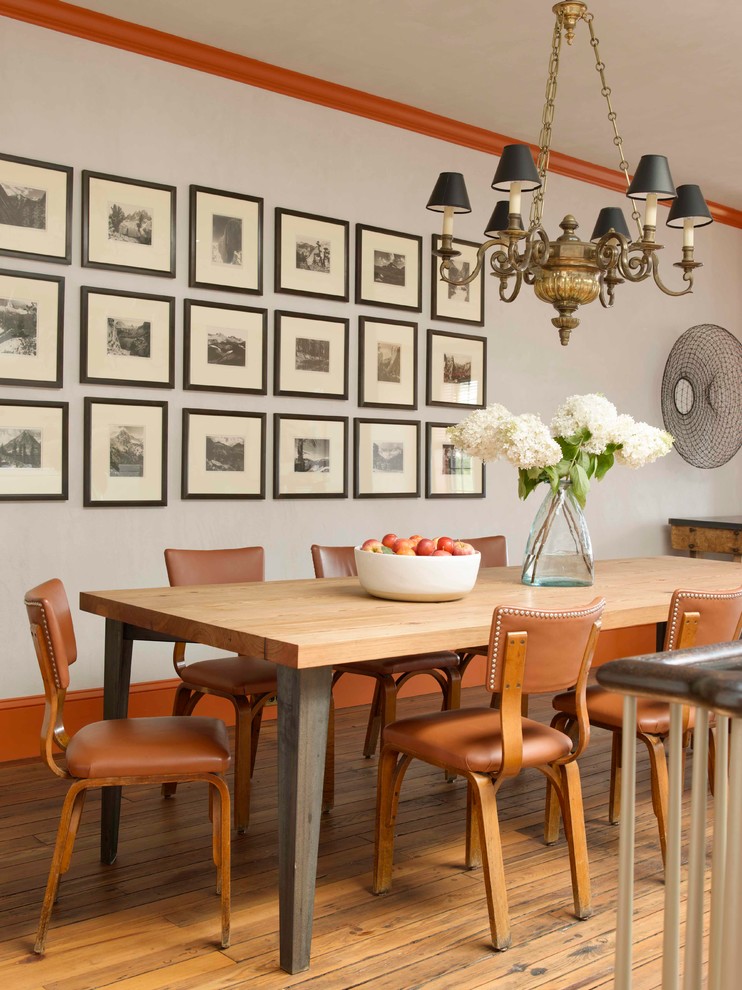 Immagine di una sala da pranzo tradizionale con pareti grigie e pavimento in legno massello medio