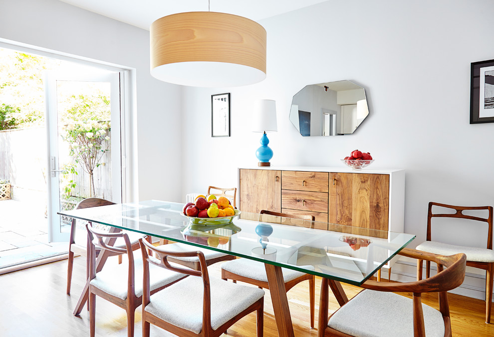 Immagine di una sala da pranzo aperta verso la cucina contemporanea di medie dimensioni con pareti bianche e parquet chiaro