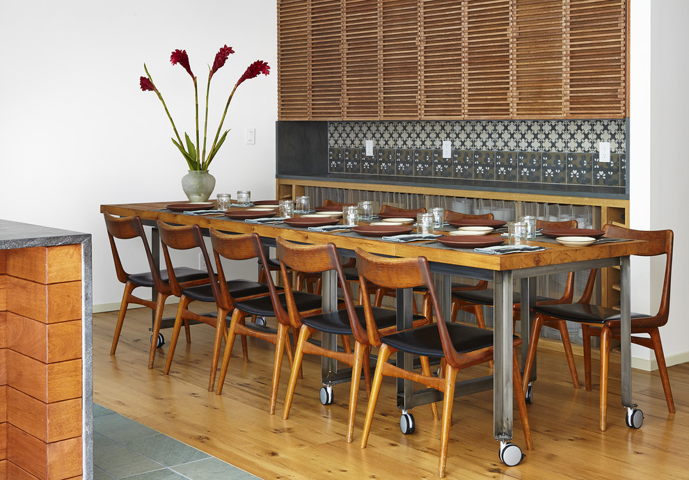 Modelo de comedor de cocina de tamaño medio con paredes blancas y suelo de madera en tonos medios