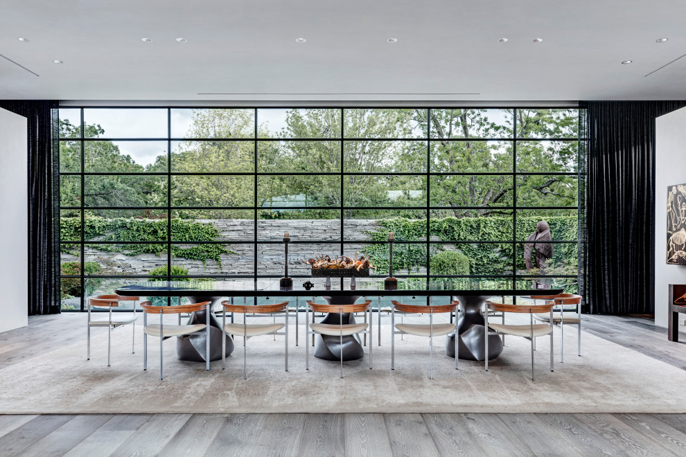 Esempio di un'ampia sala da pranzo aperta verso il soggiorno contemporanea con pareti bianche, pavimento in legno massello medio e pavimento grigio