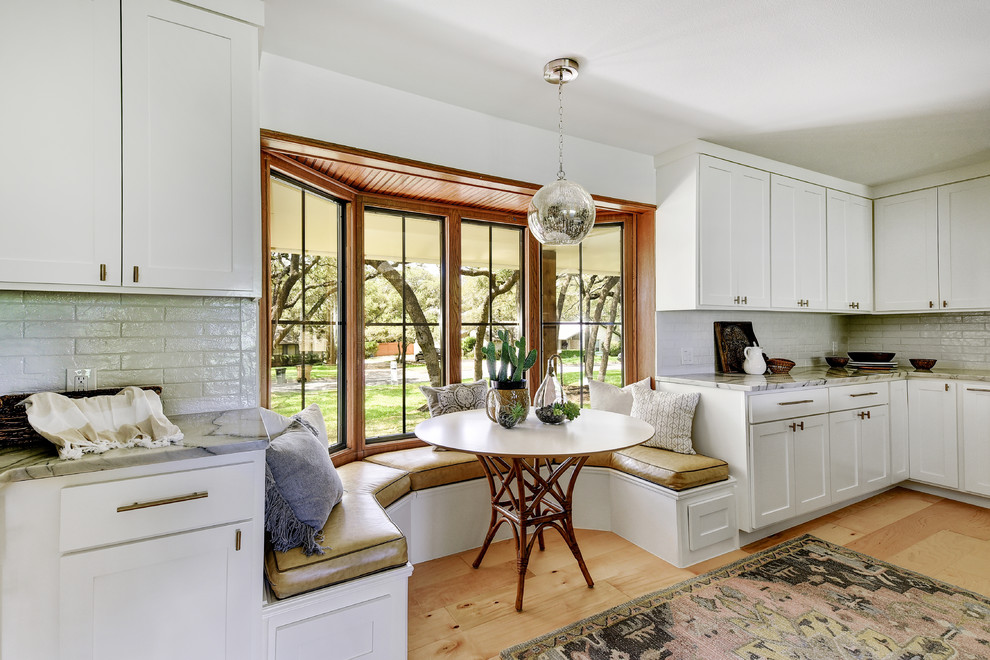 Classic kitchen/dining room in Austin with white walls, light hardwood flooring, beige floors and feature lighting.