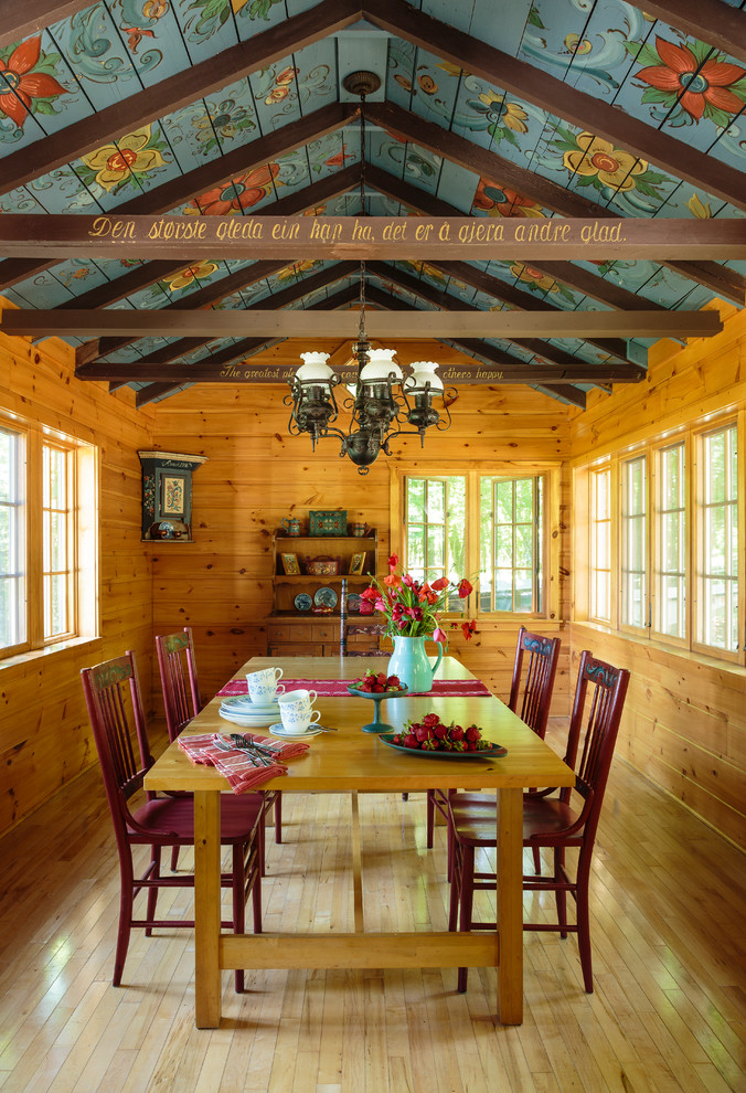 Example of a large country light wood floor and brown floor enclosed dining room design in Milwaukee with brown walls and no fireplace