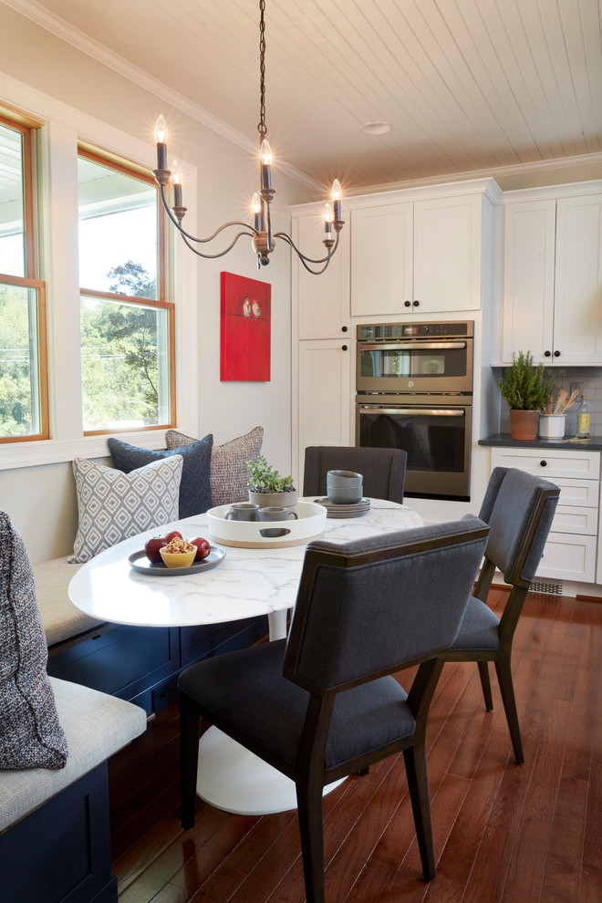 Réalisation d'une petite salle à manger ouverte sur la cuisine champêtre avec un mur blanc, parquet foncé et aucune cheminée.