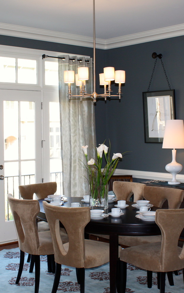 Cette image montre une salle à manger ouverte sur la cuisine traditionnelle de taille moyenne avec un mur bleu et un sol en bois brun.