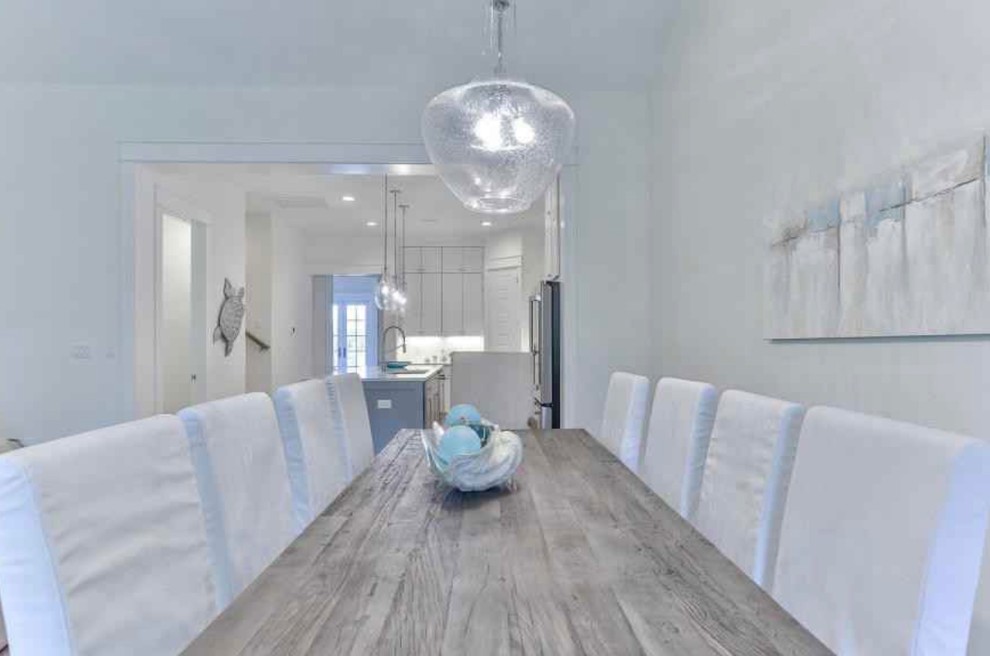 Mid-sized beach style light wood floor and beige floor kitchen/dining room combo photo in Miami with white walls and no fireplace