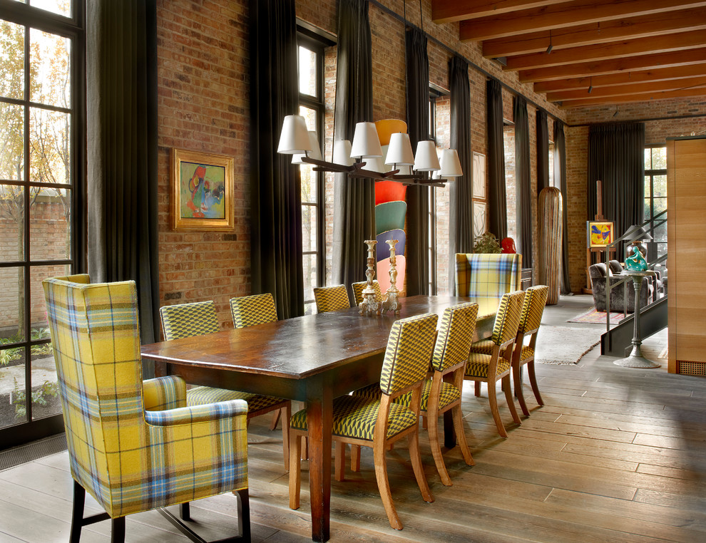Esempio di una sala da pranzo aperta verso il soggiorno industriale con pavimento in legno massello medio