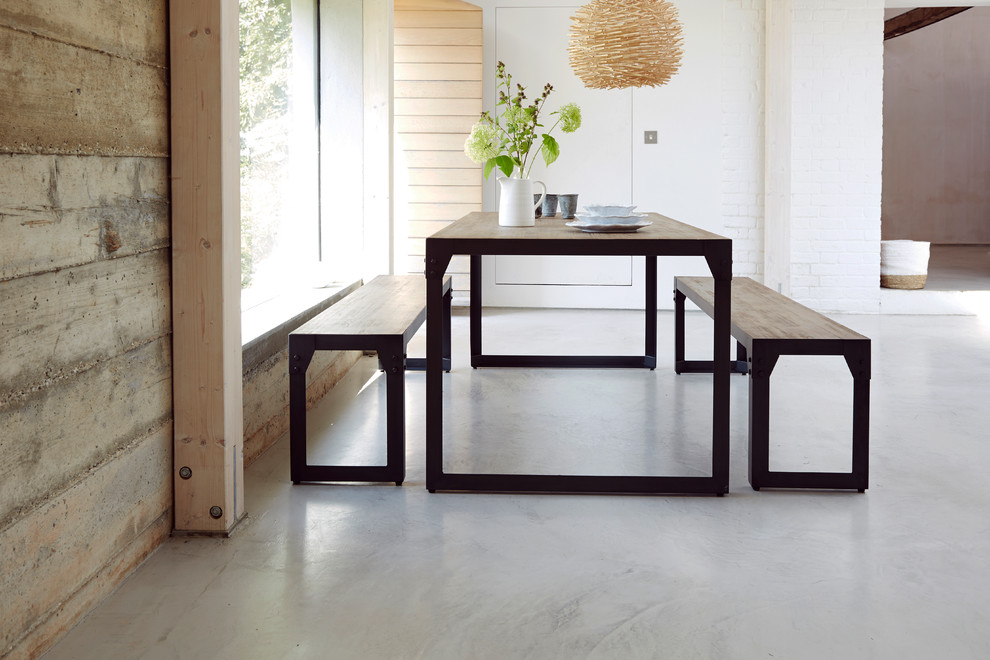 Inspiration pour une salle à manger ouverte sur la cuisine minimaliste de taille moyenne avec un mur blanc et sol en béton ciré.