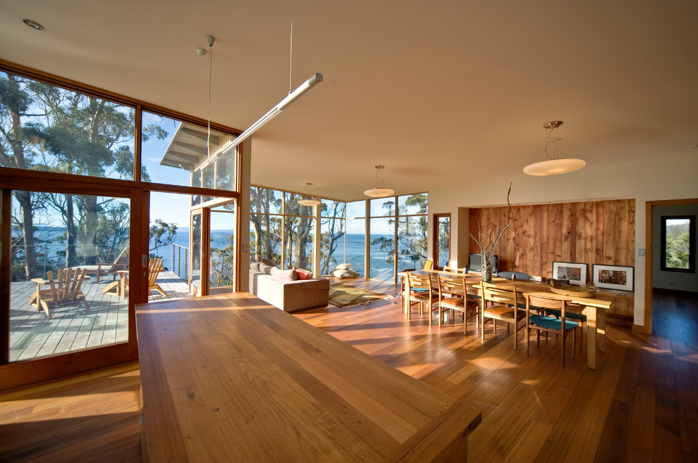 Esempio di una sala da pranzo aperta verso il soggiorno stile marino di medie dimensioni con pareti bianche e pavimento in legno massello medio