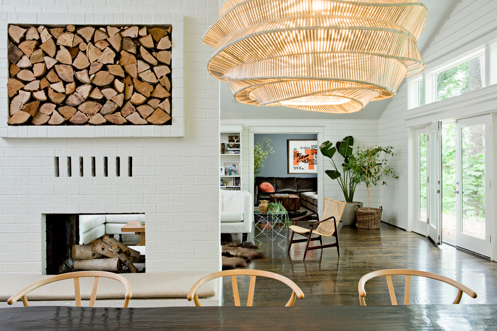 Trendy dark wood floor dining room photo in Portland with a two-sided fireplace and a brick fireplace