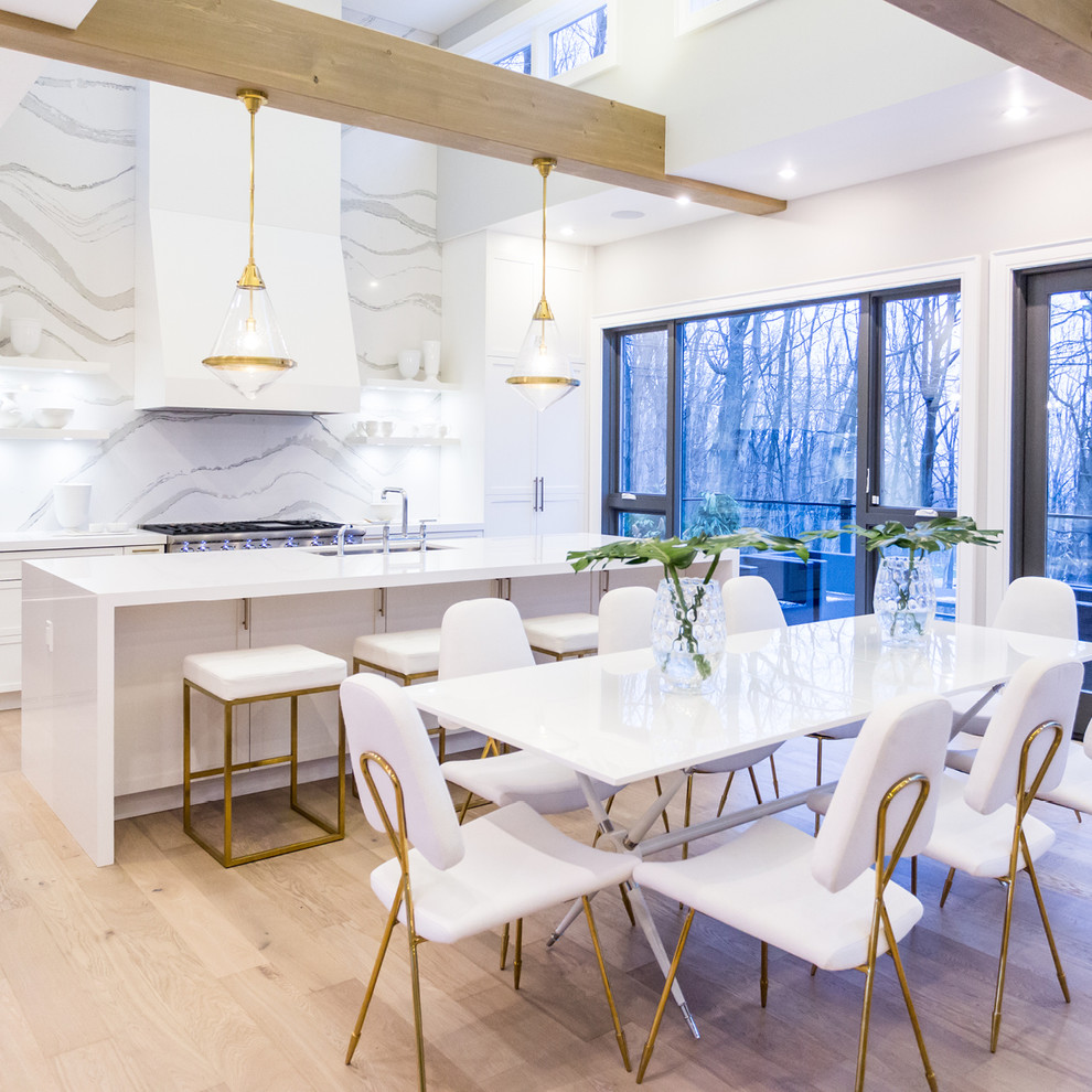 Immagine di una grande sala da pranzo aperta verso la cucina design con pareti bianche, parquet chiaro, nessun camino e pavimento beige