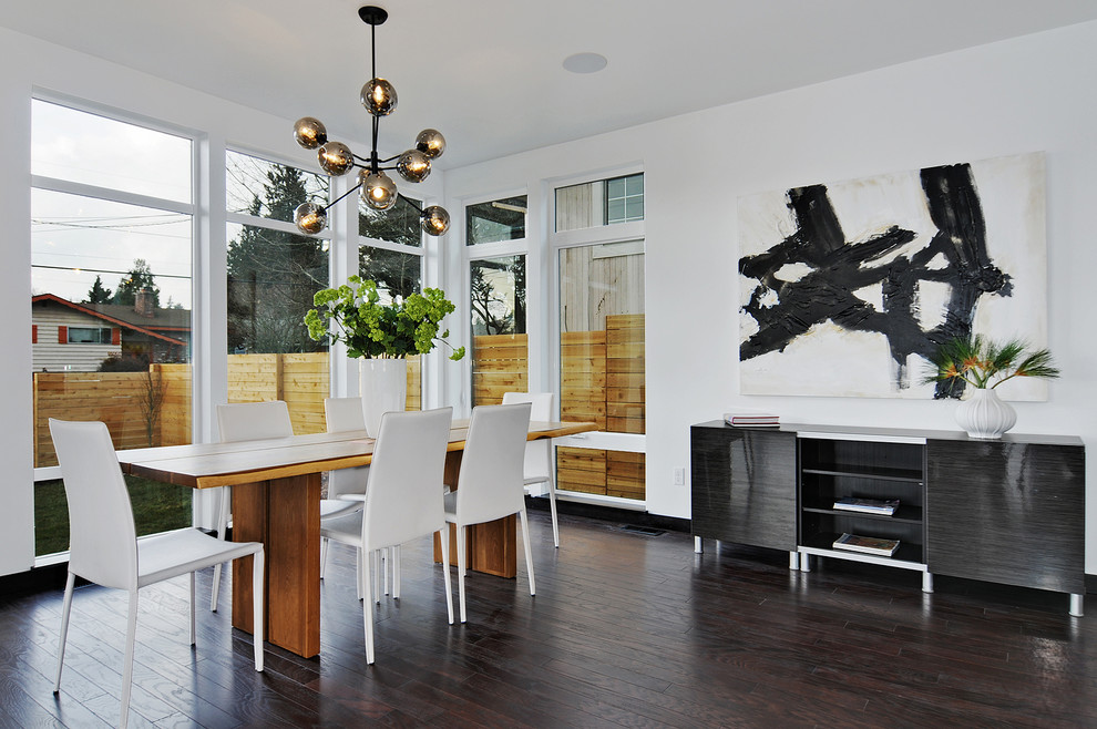 Example of a mid-sized minimalist dark wood floor and brown floor great room design in Seattle with white walls