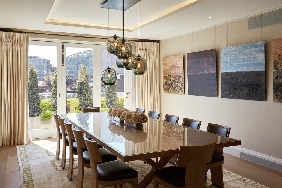 Inspiration pour une salle à manger traditionnelle avec un mur beige et parquet clair.