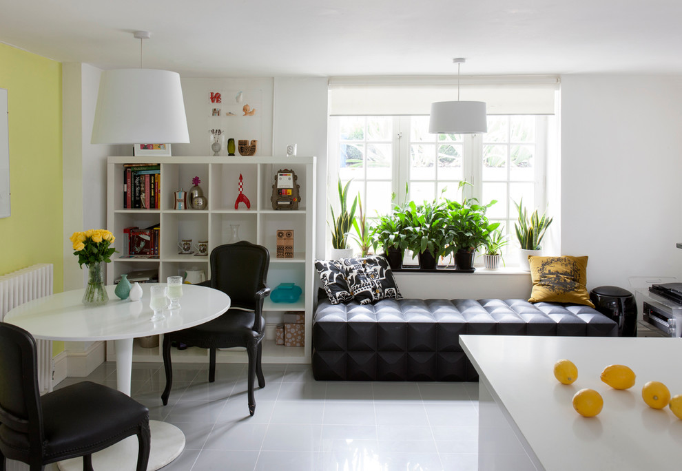 Exemple d'une salle à manger ouverte sur la cuisine éclectique de taille moyenne avec un mur jaune et un sol gris.