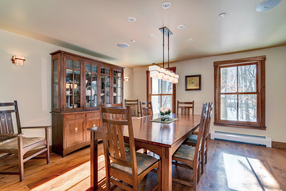 Immagine di una grande sala da pranzo american style con pareti beige, pavimento in legno massello medio, nessun camino e pavimento marrone