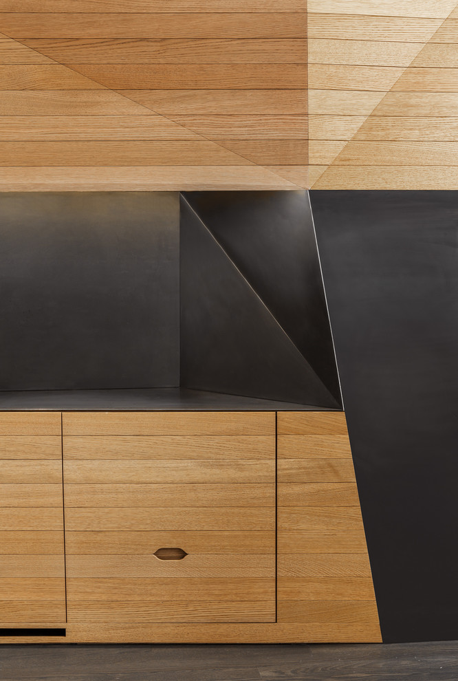 Modelo de comedor actual de tamaño medio con paredes blancas, suelo de madera oscura, chimenea de doble cara, marco de chimenea de metal y suelo marrón