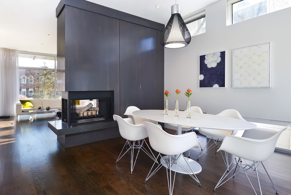 Cette image montre une salle à manger minimaliste avec une cheminée double-face.