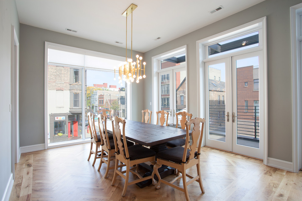 Cette image montre une salle à manger minimaliste fermée et de taille moyenne avec un mur gris, un sol en bois brun et aucune cheminée.