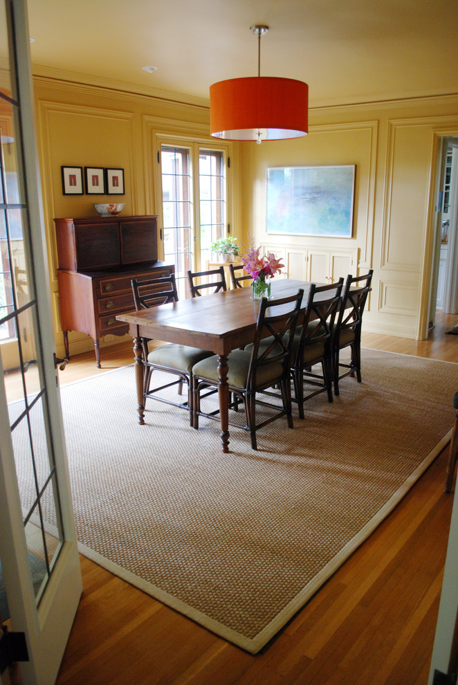 Exemple d'une grande salle à manger ouverte sur la cuisine chic avec un mur jaune et parquet clair.