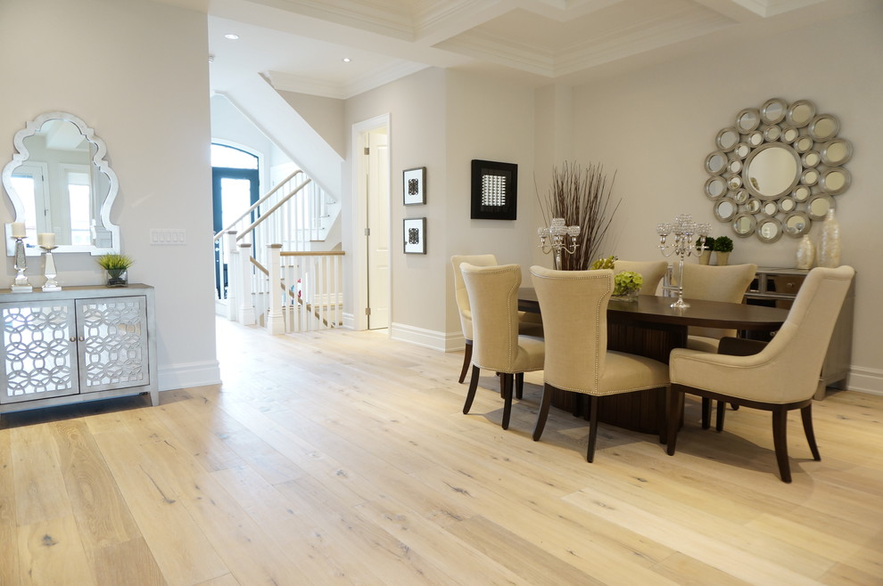 Immagine di una sala da pranzo aperta verso il soggiorno contemporanea con pareti beige e parquet chiaro