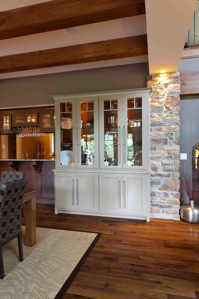 Aménagement d'une salle à manger ouverte sur la cuisine campagne de taille moyenne avec un mur beige, parquet foncé, aucune cheminée et un sol marron.