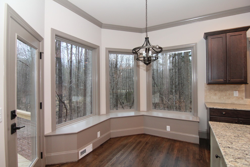 Foto di una piccola sala da pranzo aperta verso la cucina design con pareti beige e pavimento in legno massello medio