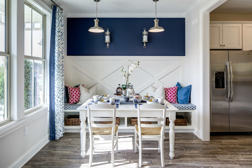 Cette image montre une salle à manger ouverte sur la cuisine traditionnelle avec un mur bleu.
