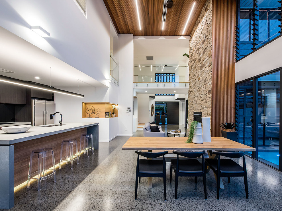 Foto di una sala da pranzo aperta verso la cucina minimal con pareti bianche e pavimento grigio