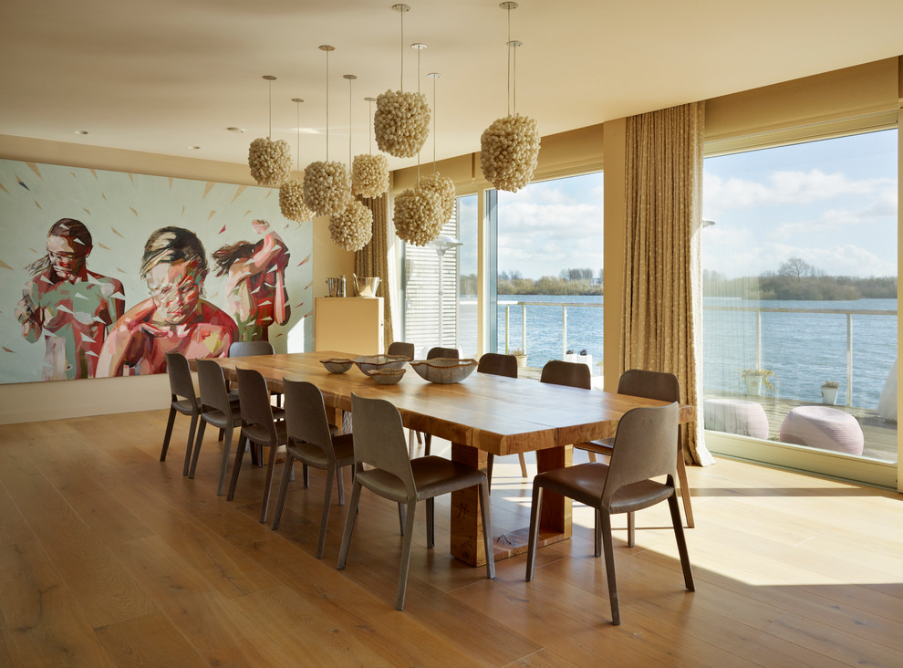 Immagine di una grande sala da pranzo aperta verso il soggiorno design con pavimento in legno massello medio e pareti beige
