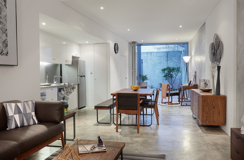 Идея дизайна: маленькая гостиная-столовая в стиле лофт с белыми стенами, бетонным полом и серым полом без камина для на участке и в саду