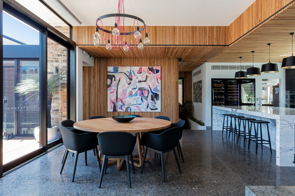 Idées déco pour une salle à manger ouverte sur la cuisine contemporaine de taille moyenne avec un mur multicolore et sol en béton ciré.