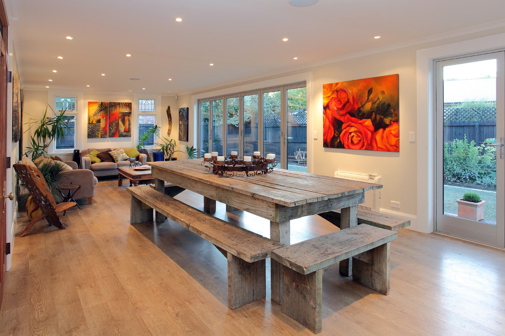 Example of a beach style light wood floor dining room design in Christchurch with beige walls and no fireplace