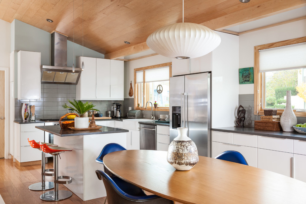 Idee per una sala da pranzo aperta verso la cucina minimalista con pavimento in legno massello medio