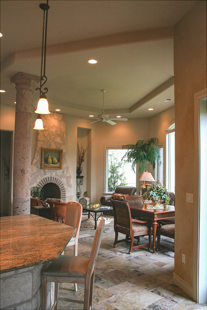 Example of a large tuscan marble floor and white floor kitchen/dining room combo design in Austin with white walls, a standard fireplace and a stone fireplace