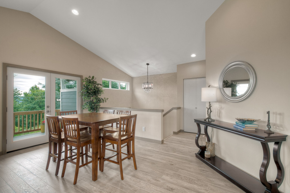 Cette image montre une salle à manger ouverte sur la cuisine design de taille moyenne avec un mur beige, parquet clair et un sol gris.