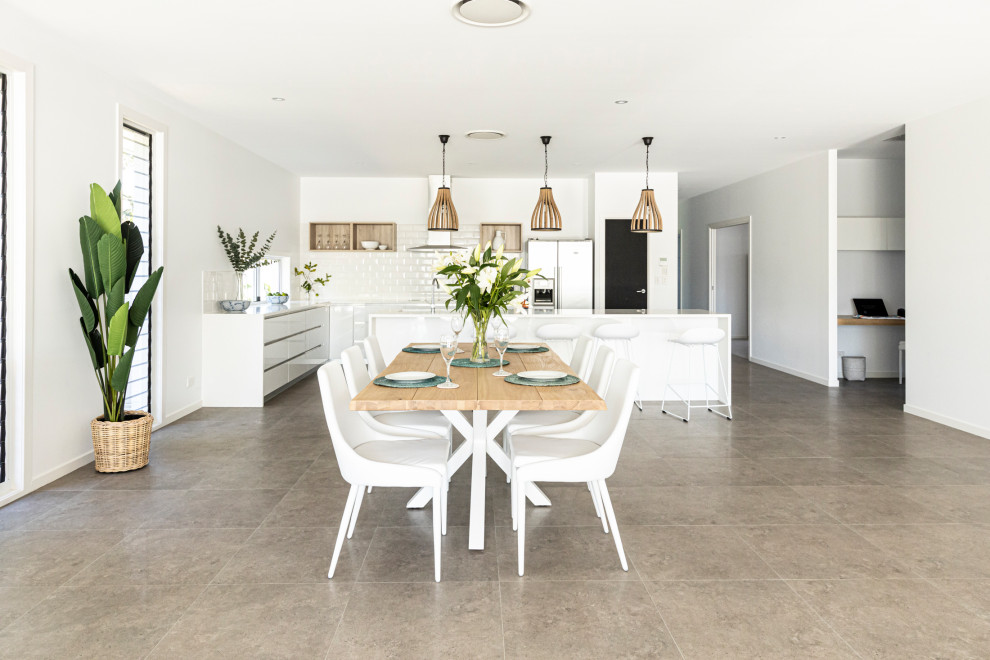 Esempio di un'ampia sala da pranzo aperta verso il soggiorno costiera con pareti bianche, pavimento in gres porcellanato e pavimento grigio