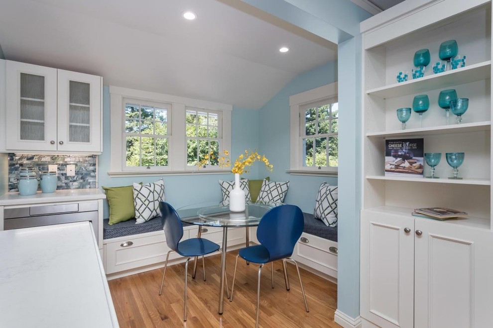 Immagine di una sala da pranzo aperta verso la cucina classica con pareti blu, parquet chiaro e nessun camino