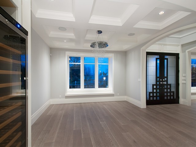 Exemple d'une salle à manger ouverte sur le salon chic de taille moyenne avec un mur gris, un sol en bois brun et aucune cheminée.