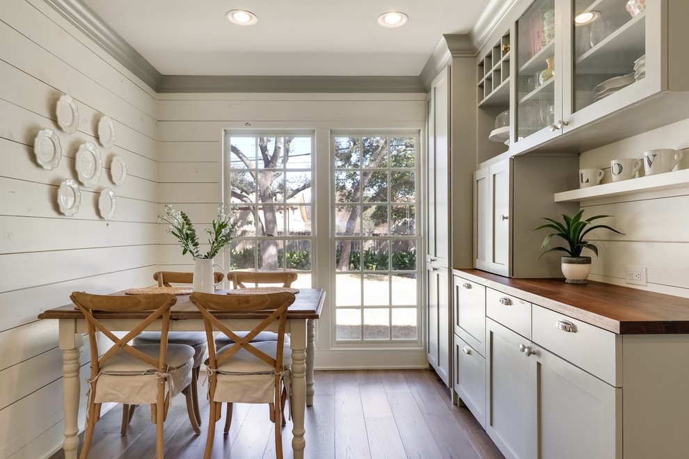Imagen de comedor de estilo de casa de campo de tamaño medio cerrado con paredes beige, suelo de madera en tonos medios y suelo marrón