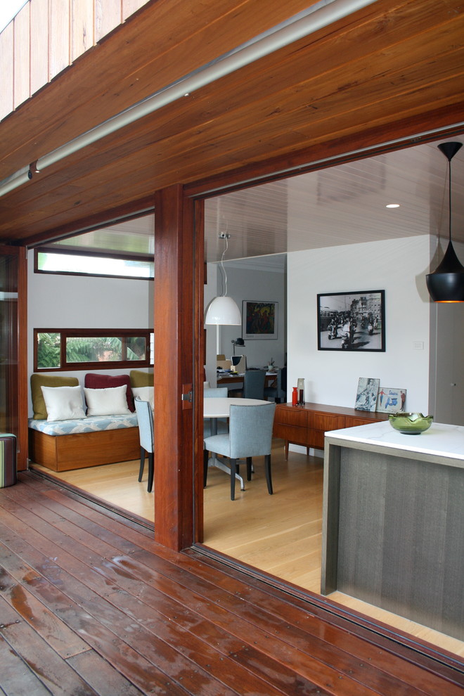 Kleine Moderne Wohnküche mit weißer Wandfarbe, hellem Holzboden und gelbem Boden in Sydney