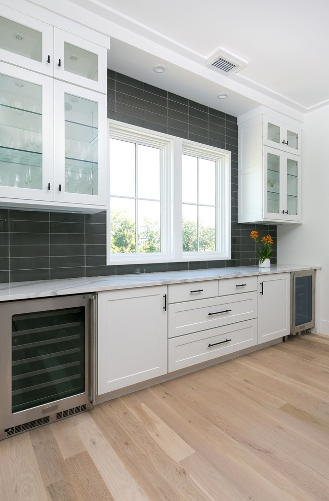 Immagine di una grande sala da pranzo aperta verso la cucina minimalista con pareti bianche, parquet chiaro e pavimento beige