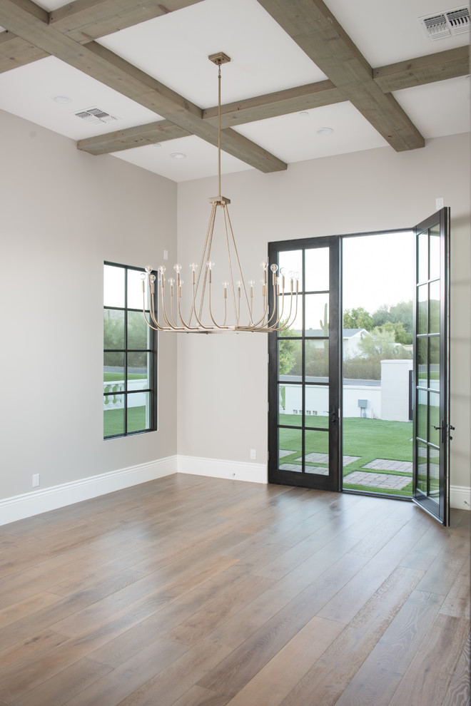 Mid-sized trendy medium tone wood floor and brown floor enclosed dining room photo in Phoenix with beige walls