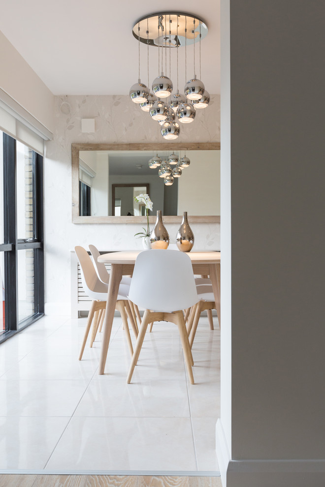 This is an example of a scandinavian enclosed dining room in Dublin with beige walls and white floors.