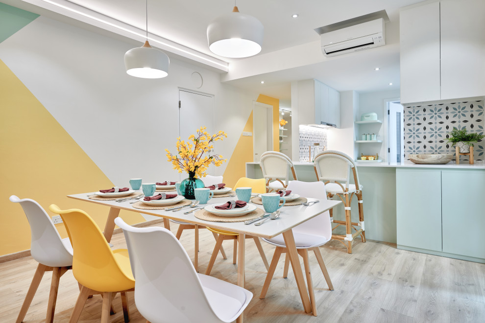 Mid-sized danish light wood floor and gray floor kitchen/dining room combo photo in Singapore with white walls