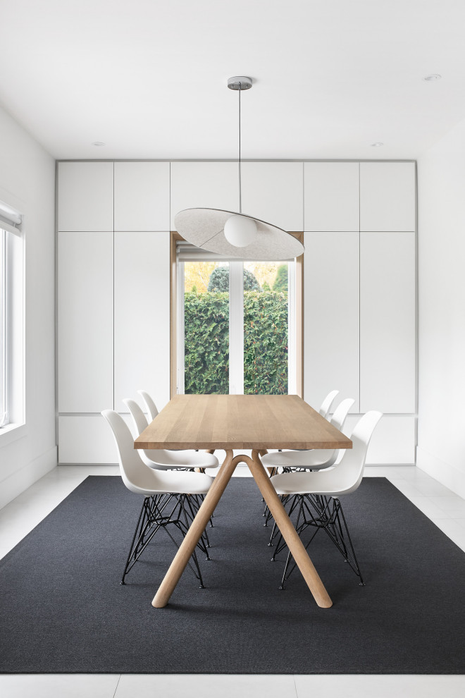 Inspiration for a medium sized modern dining room in Montreal with banquette seating, white walls, ceramic flooring and grey floors.