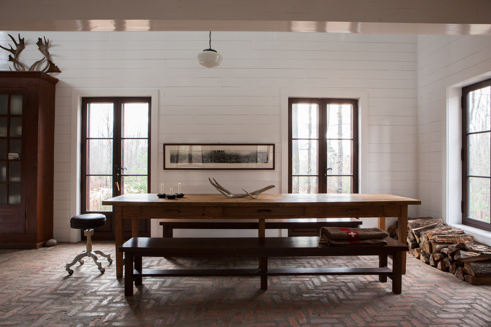 Foto di una grande sala da pranzo stile rurale con pavimento in mattoni e pareti bianche